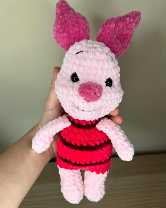 Peluche Pimpi in ciniglia rosa con maglia a righe, tenuto in mano